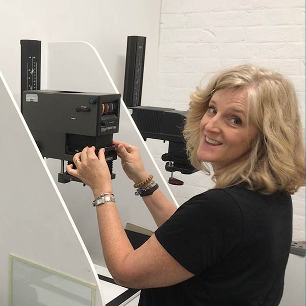 Ally putting the negative into the enlarger showing how to do darkroom printing